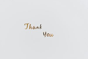 Simple and elegant gold 'Thank You' text on a clean white background, perfect for gratitude cards.
